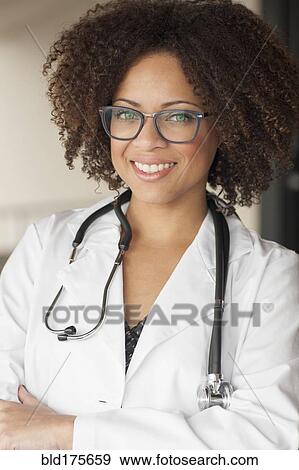 Stock Photo - Mixed race doctor smiling with arms crossed. Fotosearch