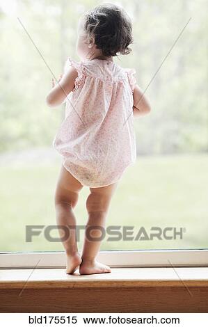 Stock Photography - Mixed race girl looking out window. Fotosearch