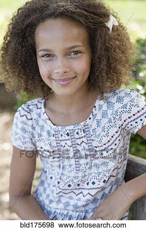 Stock Photo - Mixed race girl smiling outdoors. Fotosearch