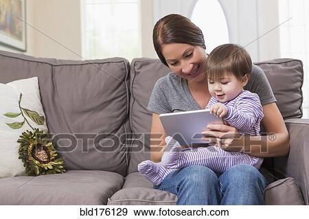 Stock Photo - Mixed race mother and baby daughter using digital tablet. Fotosearch