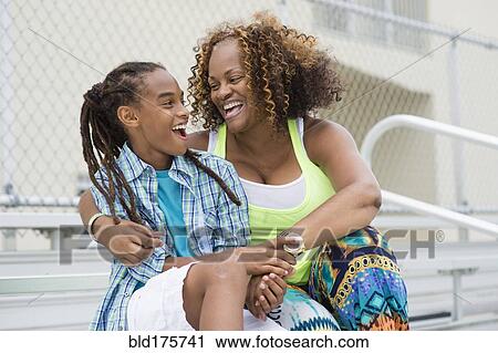 Mixed race mother and son hugging on bleachers View Large Photo Image Stock Image - Mixed race mother and son hugging on bleachers. Fotosearch