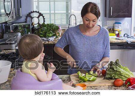 Mixed race mother chopping vegetables with daughter in kitchen View Large Photo Image Stock Image - Mixed race mother chopping vegetables with daughter in kitchen. Fotosearch