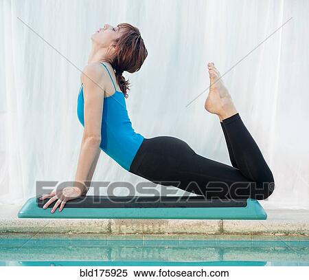 Stock Photography - Mixed race woman practicing yoga. Fotosearch