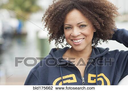 Stock Image - Mixed race woman smiling outdoors. Fotosearch