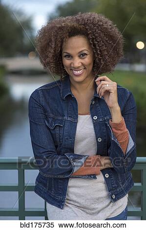 Stock Photography - Mixed race woman standing on bridge. Fotosearch