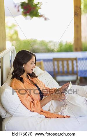 Stock Image - Mixed race woman using digital tablet. Fotosearch