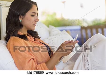 Stock Photo - Mixed race woman using digital tablet. Fotosearch