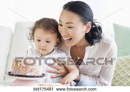 Stock Image - Mother and baby daughter celebrating birthday. Fotosearch