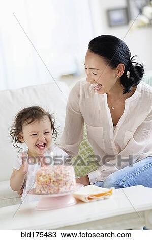 Stock Image - Mother and baby daughter celebrating birthday. Fotosearch