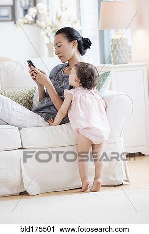 Mother and baby daughter using cell phone View Large Photo Image Stock Image - Mother and baby daughter using cell phone. Fotosearch