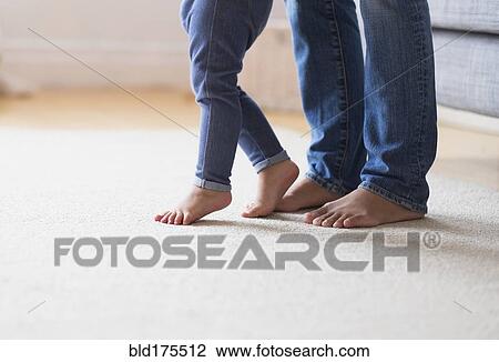 Stock Image - Mother and baby daughter with bare feet. Fotosearch