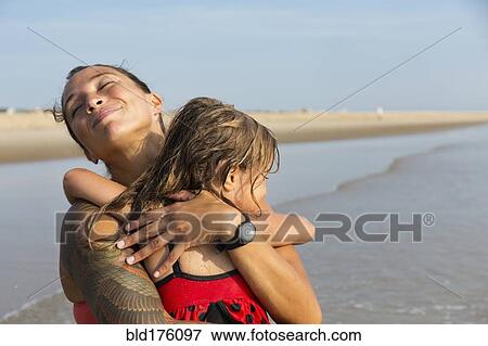 Stock Photo - Mother and daughter hugging on beach. Fotosearch