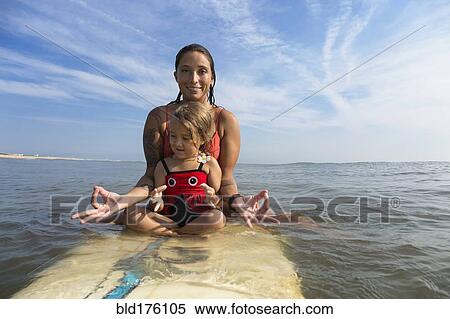 Mother and daughter meditating on surfboard View Large Photo Image Stock Photography - Mother and daughter meditating on surfboard. Fotosearch