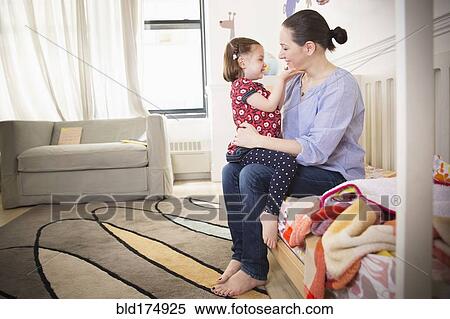 Mother and daughter sitting on bed View Large Photo Image Stock Photography - Mother and daughter sitting on bed. Fotosearch