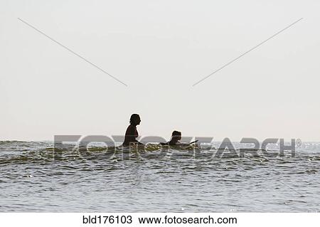Mother and daughter surfing in waves View Large Photo Image Stock Image - Mother and daughter surfing in waves. Fotosearch