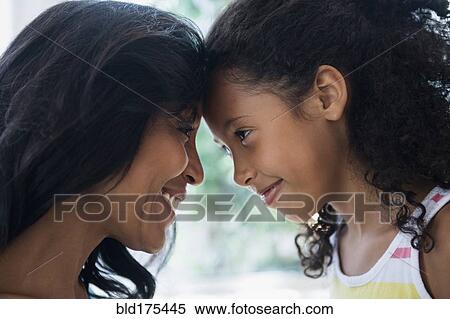 Stock Photography - Mother and daughter touching foreheads. Fotosearch