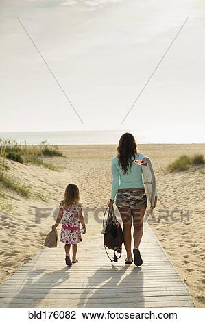 Mother and daughter walking on beach View Large Photo Image Stock Image - Mother and daughter walking on beach. Fotosearch