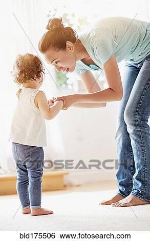 Stock Photograph - Mother comforting baby daughter. Fotosearch