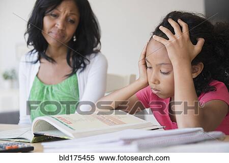 Stock Photography - Mother helping daughter with homework. Fotosearch
