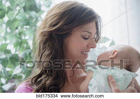 Picture - Mother holding baby daughter. Fotosearch