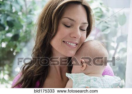 Stock Image - Mother holding baby daughter. Fotosearch