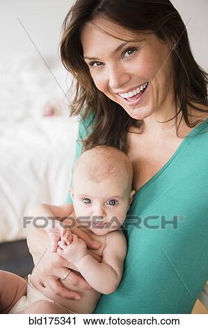 Stock Image - Mother holding baby daughter. Fotosearch
