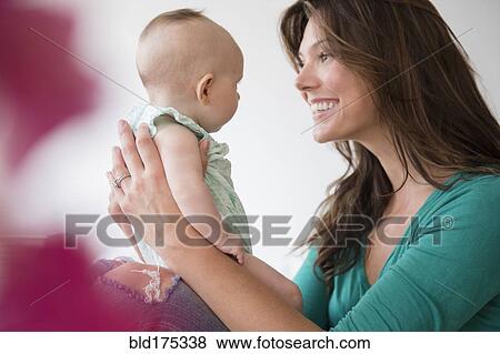 Stock Photo - Mother holding baby daughter. Fotosearch