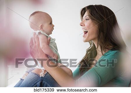 Stock Photo - Mother holding baby daughter. Fotosearch