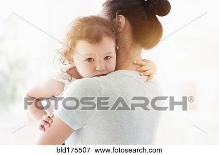 Stock Photo - Mother holding baby daughter. Fotosearch
