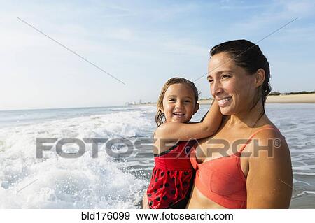 Mother holding daughter on beach View Large Photo Image Stock Photo - Mother holding daughter on beach. Fotosearch