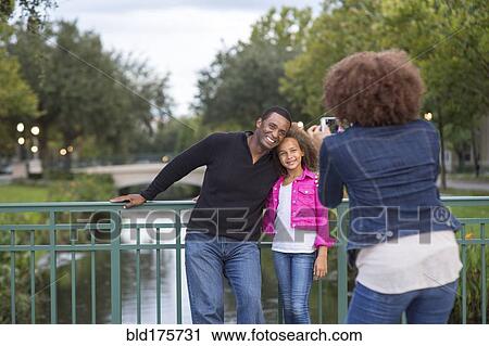 Mother photographing family on bridge View Large Photo Image Stock Image - Mother photographing family on bridge. Fotosearch