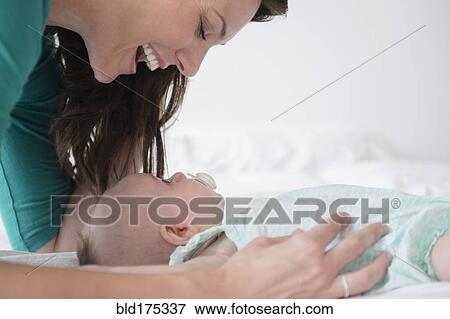 Stock Photo - Mother playing with baby daughter. Fotosearch