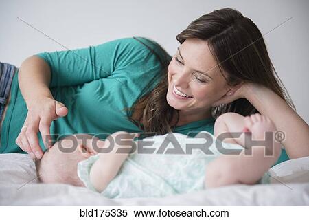 Stock Photography - Mother playing with baby daughter. Fotosearch