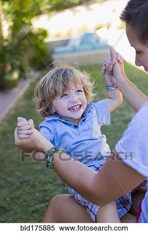 Stock Photography - Mother playing with son in backyard. Fotosearch