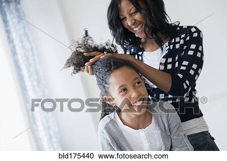 Mother styling hair of daughter View Large Photo Image Stock Image - Mother styling hair of daughter. Fotosearch