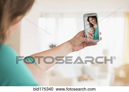 Stock Image - Mother taking selfie with baby daughter. Fotosearch