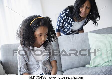 Stock Photo - Mother watching sulking daughter. Fotosearch