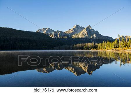 Stock Photography - Mountain reflecting in still lake. Fotosearch