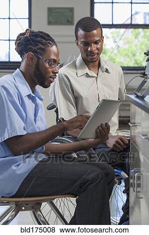 Paraplegic student and classmate using digital tablet View Large Photo Image Stock Photo - Paraplegic student and classmate using digital tablet. Fotosearch