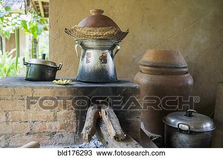 Stock Image - Pots cooking food over wood stove in outdoor kitchen. Fotosearch