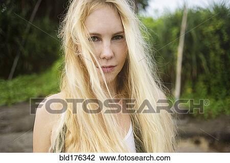 Stock Image - Serious Caucasian woman standing on beach. Fotosearch