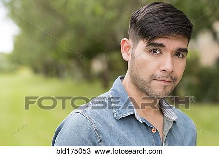 Stock Image - Serious Hispanic man outdoors. Fotosearch