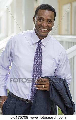 Smiling Black businessman standing outdoors View Large Photo Image Stock Photo - Smiling Black businessman standing outdoors. Fotosearch