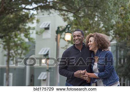 Stock Photo - Smiling couple holding hands outdoors. Fotosearch