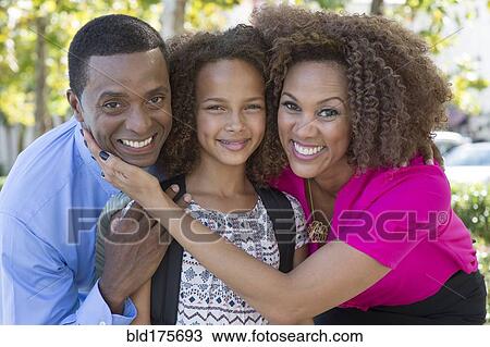 Smiling family hugging outdoors View Large Photo Image Stock Image - Smiling family hugging outdoors. Fotosearch
