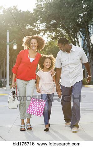 Smiling family walking outdoors View Large Photo Image Stock Photograph - Smiling family walking outdoors. Fotosearch