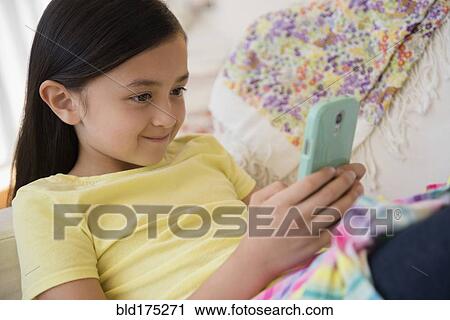 Smiling girl using cell phone View Large Photo Image Stock Image - Smiling girl using cell phone. Fotosearch