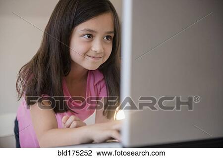 Stock Image - Smiling girl using laptop. Fotosearch