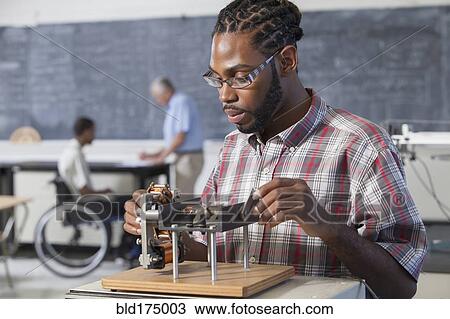 Stock Image - Student performing experiment in science classroom. Fotosearch