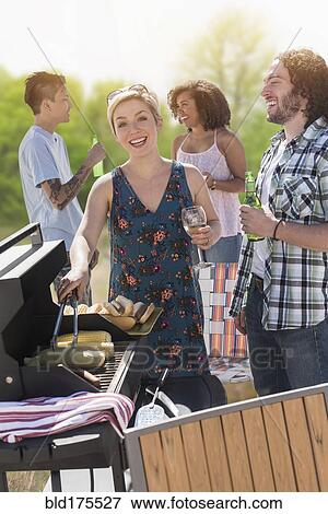 Woman serving hot dogs at barbecue View Large Photo Image Stock Photo - Woman serving hot dogs at barbecue. Fotosearch
